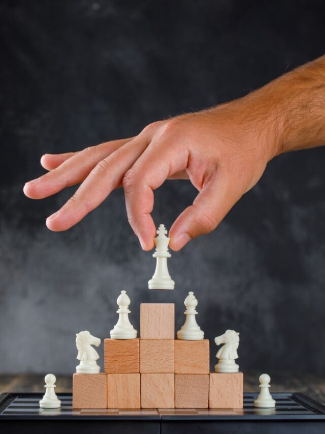 cropped-business-success-concept-with-chessboard-side-view-man-placing-figure-pyramid-blocks_176474-9274.jpg